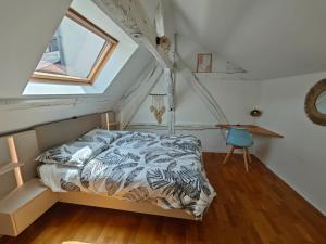 ein Schlafzimmer mit einem Bett im Dachgeschoss in der Unterkunft Le nid de l'île in Amboise