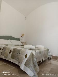 Un dormitorio con una cama con una manta. en Villa Confalonieri, en Tricase