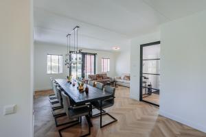 a dining room and living room with a table and chairs at Brand new bright luxurious villa in Amsterdam! in Amsterdam