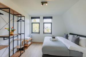 a bedroom with a bed and a staircase and windows at Brand new bright luxurious villa in Amsterdam! in Amsterdam