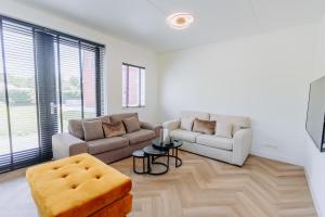 a living room with two couches and a table at Brand new bright luxurious villa in Amsterdam! in Amsterdam