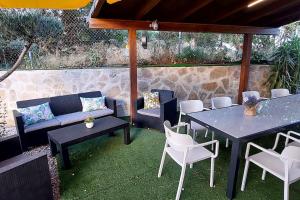 a patio with a couch and tables and chairs at Bravaholidays-600-Mas Altaba in Terra Brava