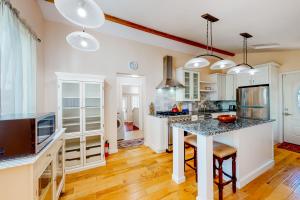 una cocina con armarios blancos y una mesa con sillas. en Tranquil Haven Cottage Retreat, en San Rafael