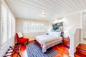 a bedroom with a bed and a red chair at Tranquil Haven Cottage Retreat in San Rafael