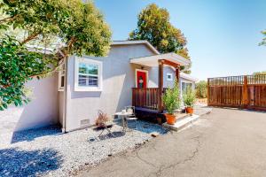 a small white house with a fence in a driveway at Tranquil Haven Cottage Retreat in San Rafael