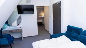 a room with a tv and a couch and a chair at Bon Żur in Brzeg