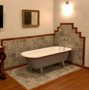 uma banheira na casa de banho com um espelho em Casona Gloria em Tarija