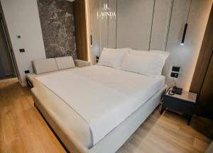 a large white bed in a small room at La Onda Hotel Durres in Durrës