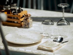 a table with a plate and a wine glass at La Onda Hotel Durres in Durrës