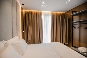 a bedroom with a white bed and a window at La Onda Hotel Durres in Durrës