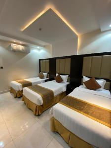 ein Hotelzimmer mit 3 Betten in der Unterkunft Alwan apartment hotel in Chamis Muschait