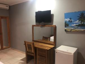 a room with a mirror and a television on a wall at Hotel Cambri in Nagua