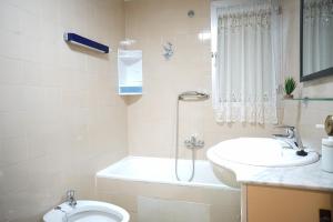 a bathroom with a sink and a tub and a toilet at Bonito apartamento en primera línea de playa in Motril
