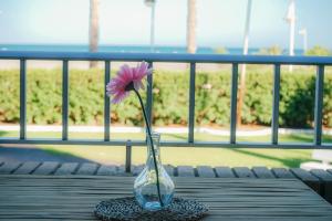 a vase with a pink flower sitting on a table at Bonito apartamento en primera línea de playa in Motril