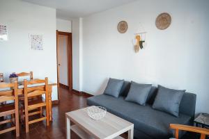 a living room with a blue couch and a table at Bonito apartamento en primera línea de playa in Motril
