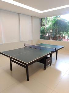 a ping pong table in the middle of a room at Flat em São Vicente com piscina na cobertura in Rio Grande da Serra