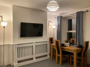 a living room with a table and a television on a wall at 4 beds for 5 people beautiful apartment . in Plymouth