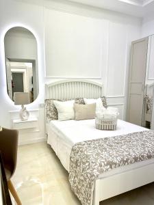 Un dormitorio blanco con una cama y un espejo. en Ferdinando's Home, en Nápoles