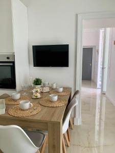Una mesa de comedor con sillas y un televisor en la pared. en Ferdinando's Home, en Nápoles 23 fotos más