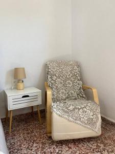una camera da letto con una sedia e un tavolino di Cactus villa a Karpathos