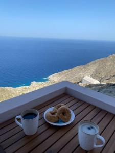 two donuts on a plate next to two cups of coffee at Cactus villa in Karpathos Town
