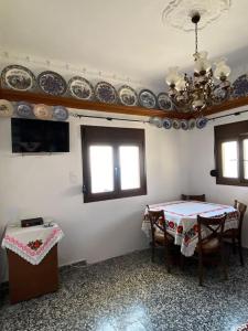 a dining room with a table and plates on the wall at Cactus villa in Karpathos