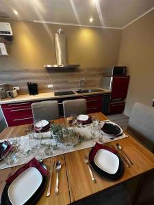 拉羅什－阿登的住宿－Le Coin Rocheux，厨房里一张木桌,上面放有盘子和玻璃杯