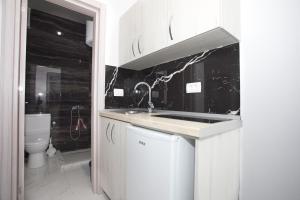 - une cuisine blanche avec un lavabo et des toilettes dans l'établissement NESI Apartments, à Ulcinj