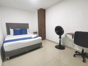 1 dormitorio con 1 cama, escritorio y ventilador en Andaliving Campo Valdes Apartamento, en Medellín