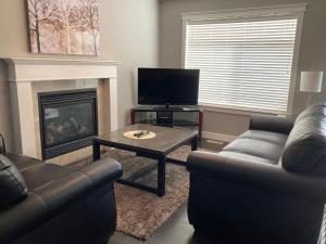 a living room with two couches and a fireplace at Signature Suites By Oasis Corporate Rentals in Grande Prairie