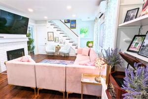 a living room with a pink couch and a fireplace at The Jewel of The Cove in New Haven