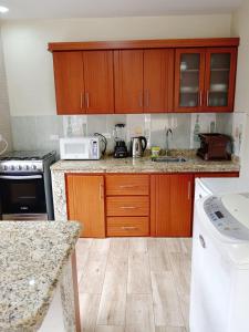 a kitchen with wooden cabinets and a counter top at Bienvenido a tu casa en Baños in Baños