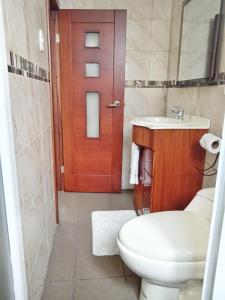 baño con aseo y lavabo y puerta de madera en Bienvenido a tu casa en Baños, en Baños