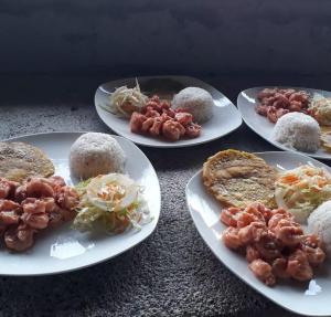 una mesa con cuatro platos de comida. en HOSTAL CRUZ DEL MAR, en Capurganá