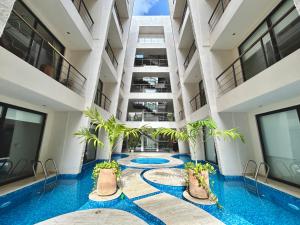 una piscina cubierta con palmeras en un edificio en Beautiful Rooftop Apartment with Private Terrace, Infinity Pool with Aerial Views, Jacuzzi-Sauna-Gym-Cinema-Coworking, en Tulum