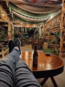 La Terraza Hostel في فلوريس: شخص يستلقي على طاولة مع زجاجة من البيرة