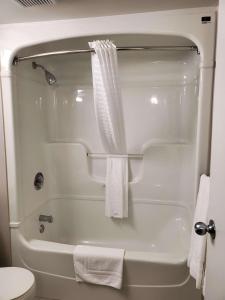 a bathroom with a tub and a shower with a toilet at Best Western Hotel Brossard in Brossard