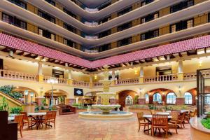 a hotel lobby with a fountain and tables and chairs at Embassy Suites by Hilton Kansas City Plaza in Kansas City