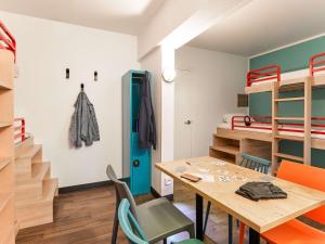 a room with a table and chairs and bunk beds at hotelF1 Saint Witz A1 Hôtel in Saint-Witz