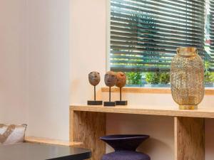 a shelf with three vases on it next to a window at ibis Styles Paris Boulogne Marcel Sembat in Boulogne-Billancourt