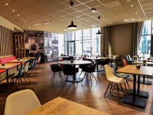 um restaurante com mesas e cadeiras e mesas e mesa em Ibis budget Dijon Centre Clemenceau em Dijon