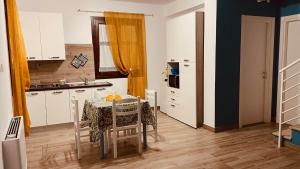 eine Küche mit einem Tisch und eine Küche mit einem Waschbecken in der Unterkunft L'angolo in centro in Partinico