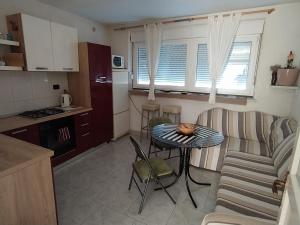 una cucina e un soggiorno con tavolo e divano di Liburana Apartment a Fiume (Rijeka)