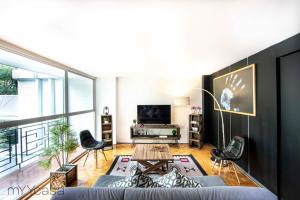 een woonkamer met een bank en stoelen en een tv bij Amsterdam - Deluxe Apartment with Furnished Balcony in La Condesa in Mexico-Stad