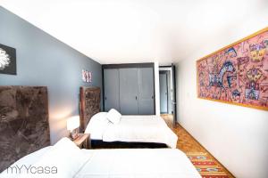 1 dormitorio con 2 camas y un cuadro en la pared en Amsterdam - Deluxe Apartment with Furnished Balcony in La Condesa en Ciudad de México