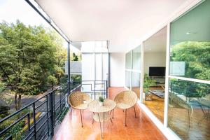 un balcón con mesa y sillas. en Amsterdam - Deluxe Apartment with Furnished Balcony in La Condesa en Ciudad de México