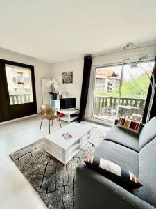 a living room with a couch and a table at Vacances paradisiaques à la plage in Deauville