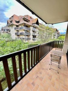 - un balcon avec un banc et un grand bâtiment dans l'établissement Vacances paradisiaques à la plage, à Deauville