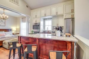 a kitchen with a large island with bar stools at Cozy Savannah Vacation Rental with Fenced Courtyard! in Savannah