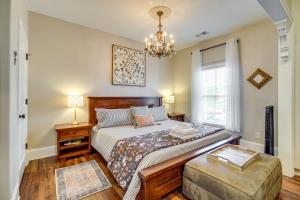 a bedroom with a large bed and a chandelier at Cozy Savannah Vacation Rental with Fenced Courtyard! in Savannah